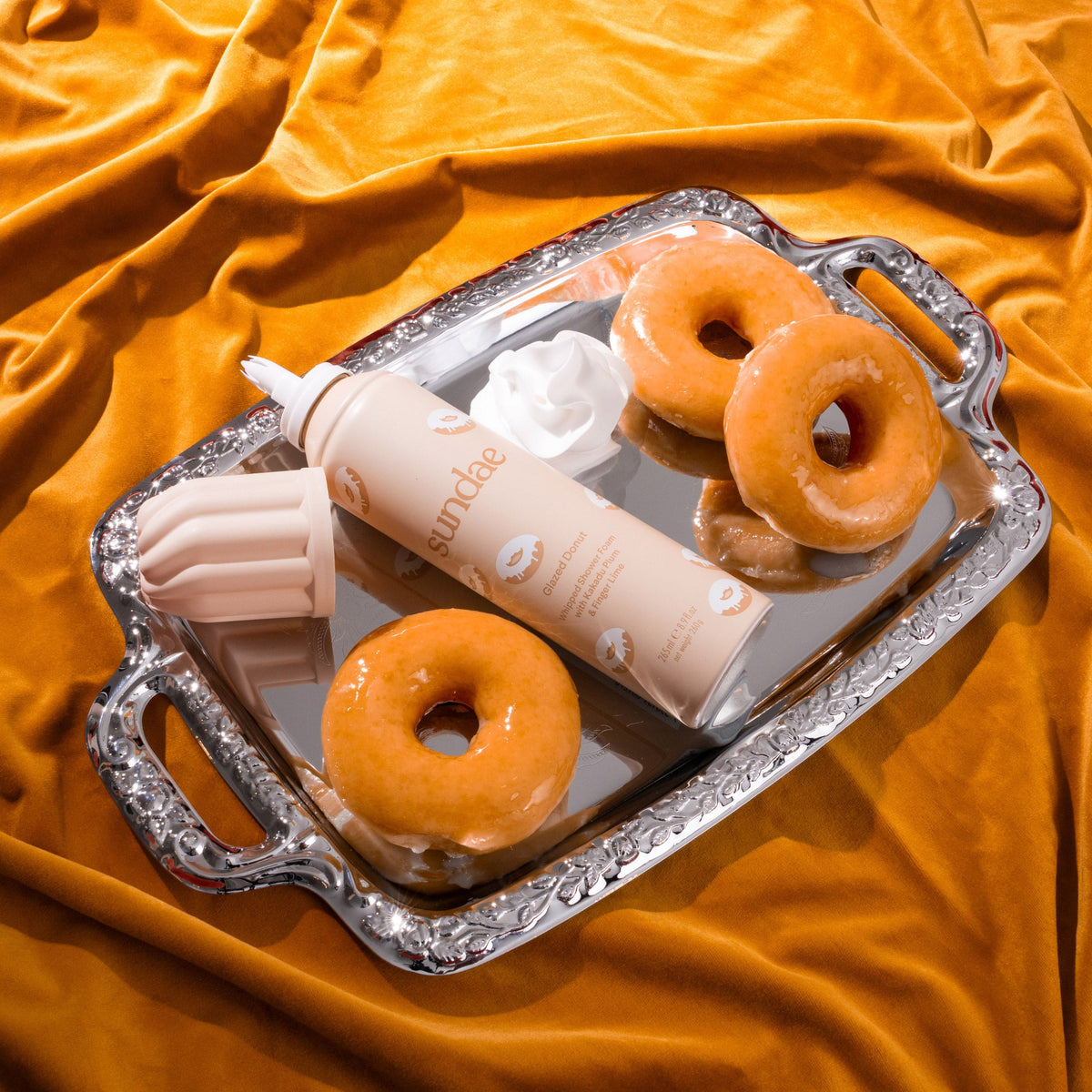 Gel douche moussant Glazed Donut Sundae Body et deux donuts sur un plateau, tissu orange